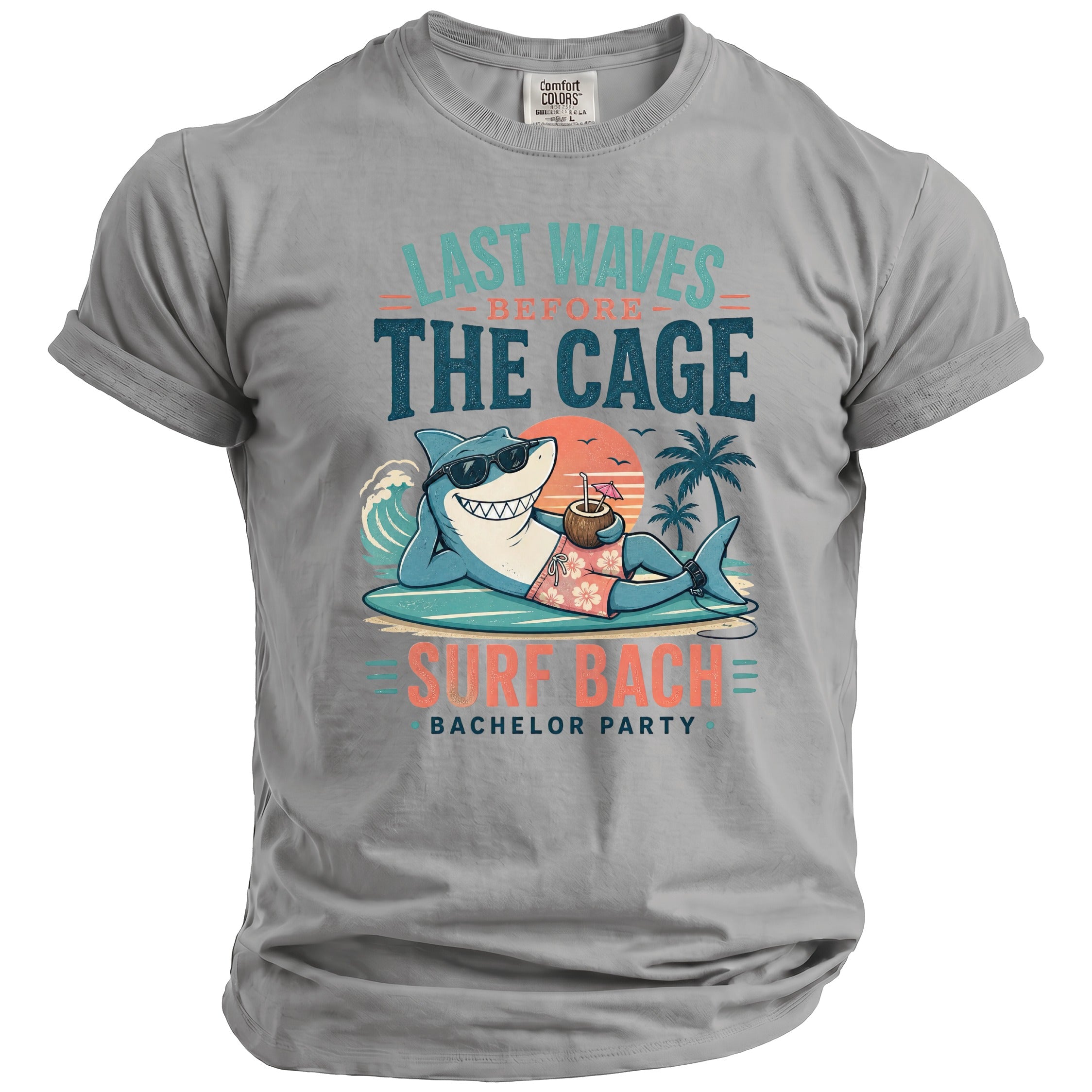 Gray t-shirt with a graphic of a shark relaxing on a surfboard with "Last Waves Before The Cage" and "Surf Bach Bachelor Party" text.