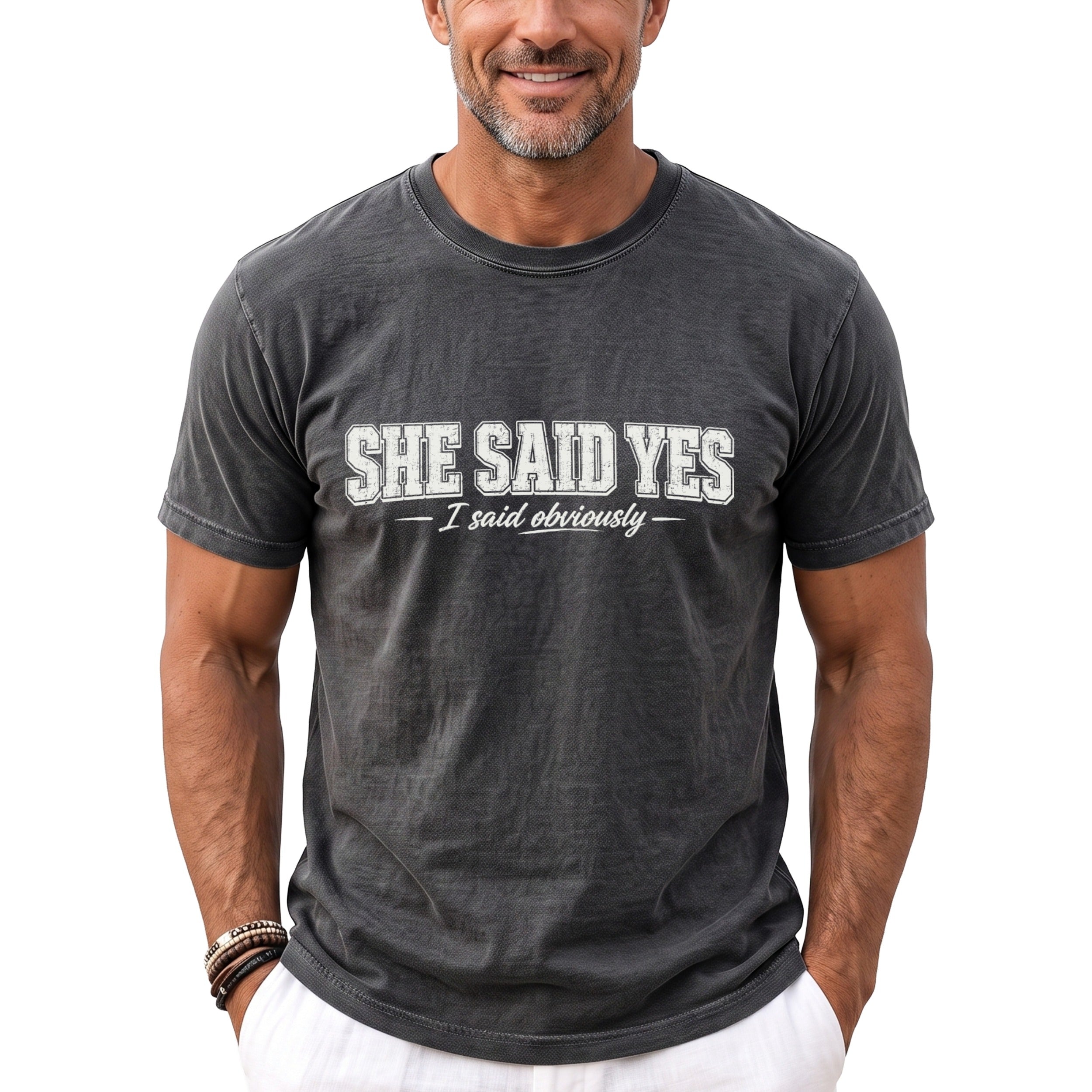Dark gray t-shirt with white text reading "SHE SAID YES - I said obviously".