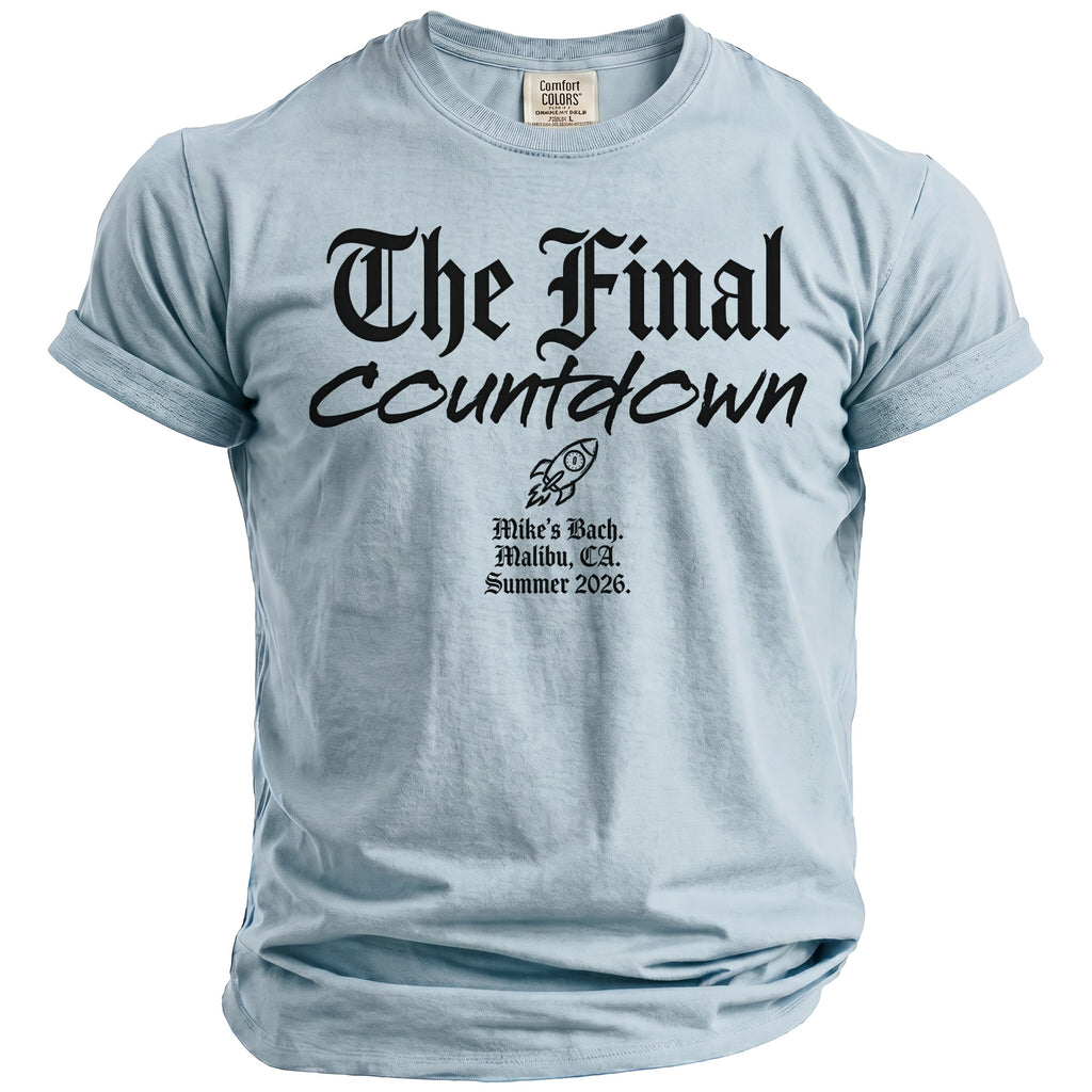 Light blue t-shirt with black text: "The Final Countdown," rocket, and "Mike's Bach. Malibu, CA. Summer 2026."