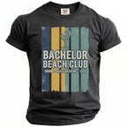 Dark gray t-shirt with "Bachelor Beach Club Groom's Beach Weekend - 2026" graphic.