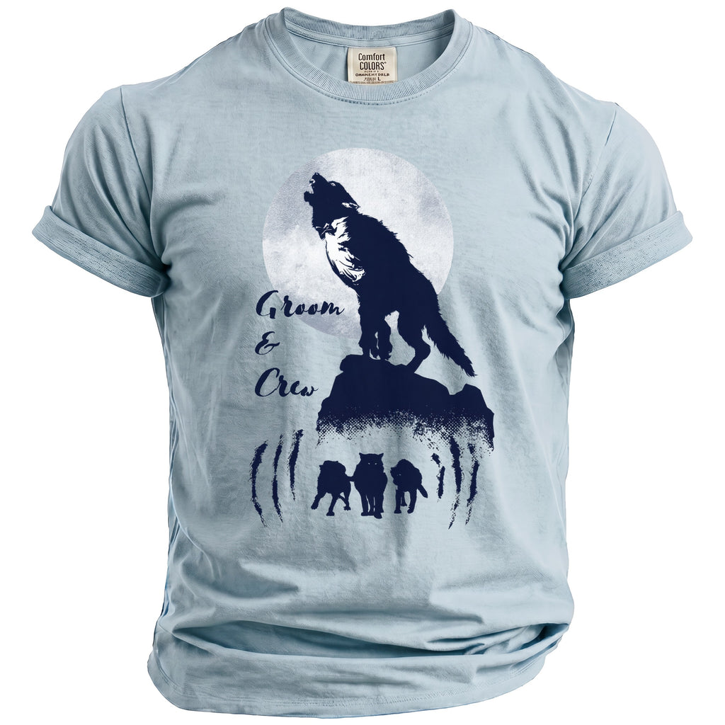 Light blue t-shirt with navy graphic of wolves, a full moon, and text reading "Groom & Crew".