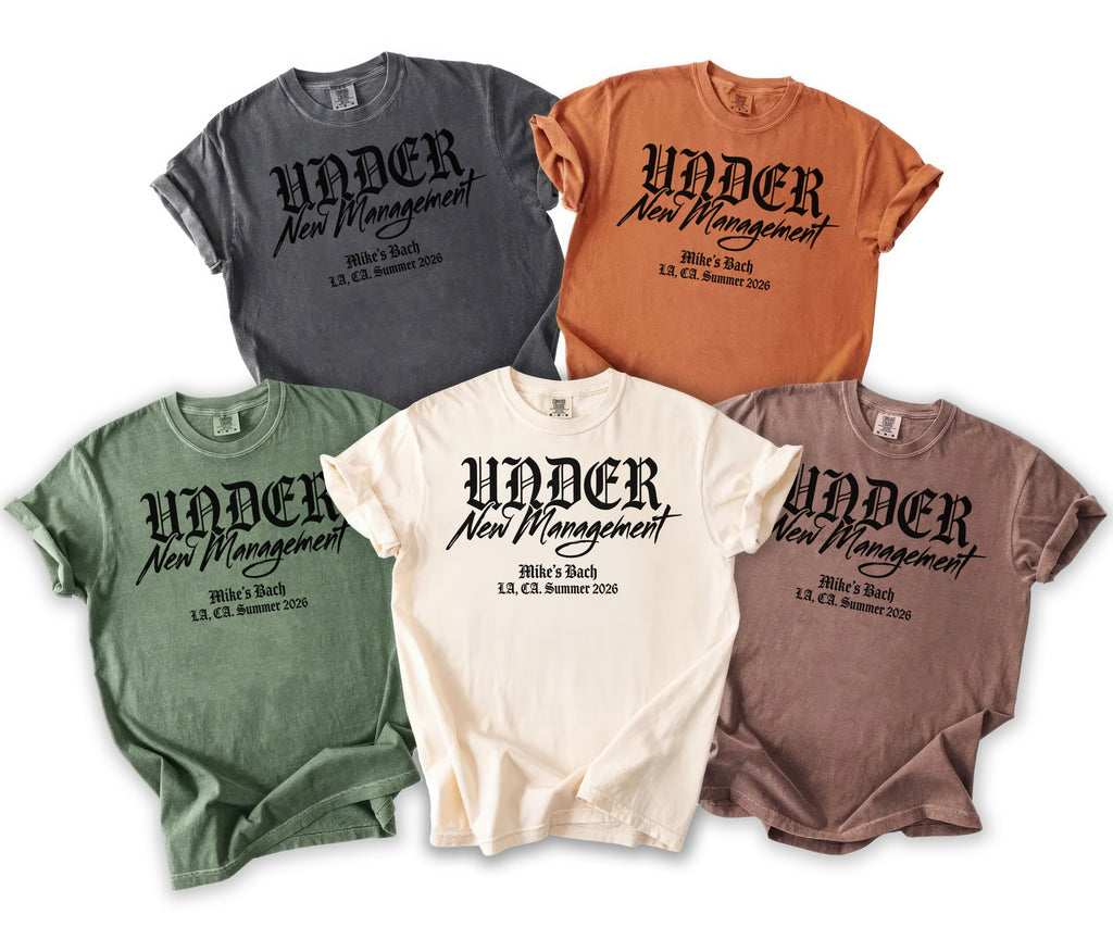 Five t-shirts in various colors with "UNDER New Management" text.