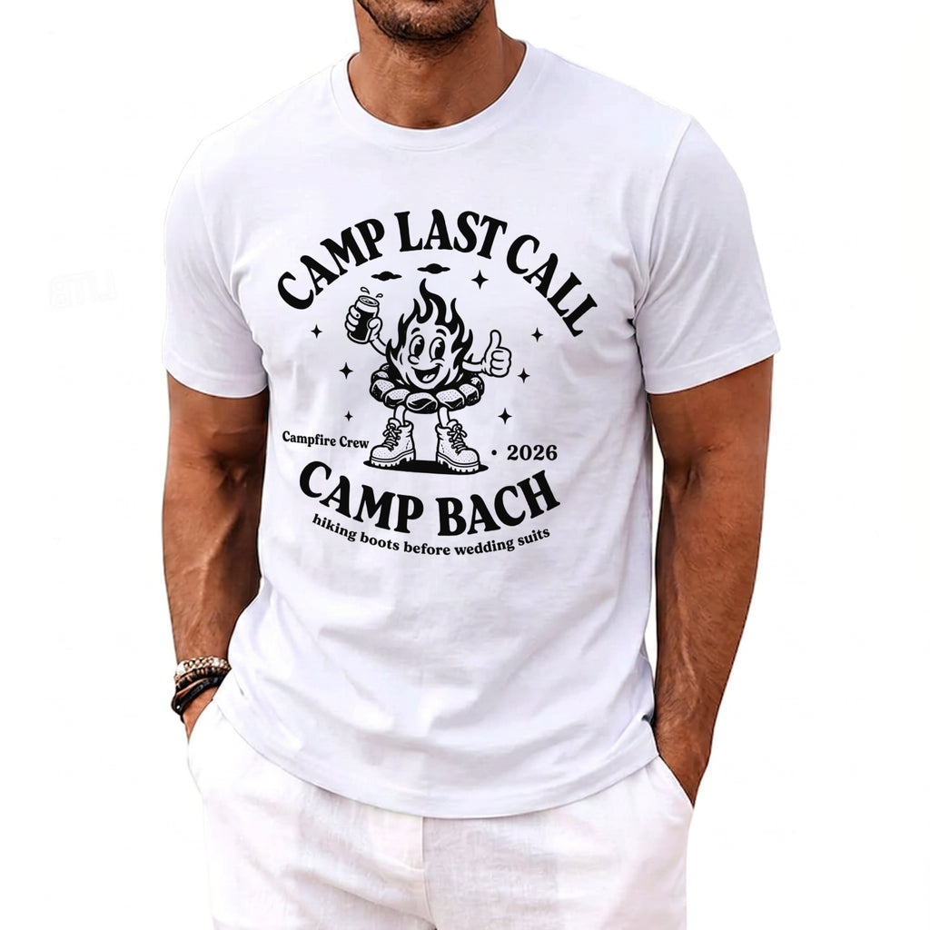 A white t-shirt features a black graphic with text reading Camp Last Call Camp Bach and a cartoon campfire character wearing boots.