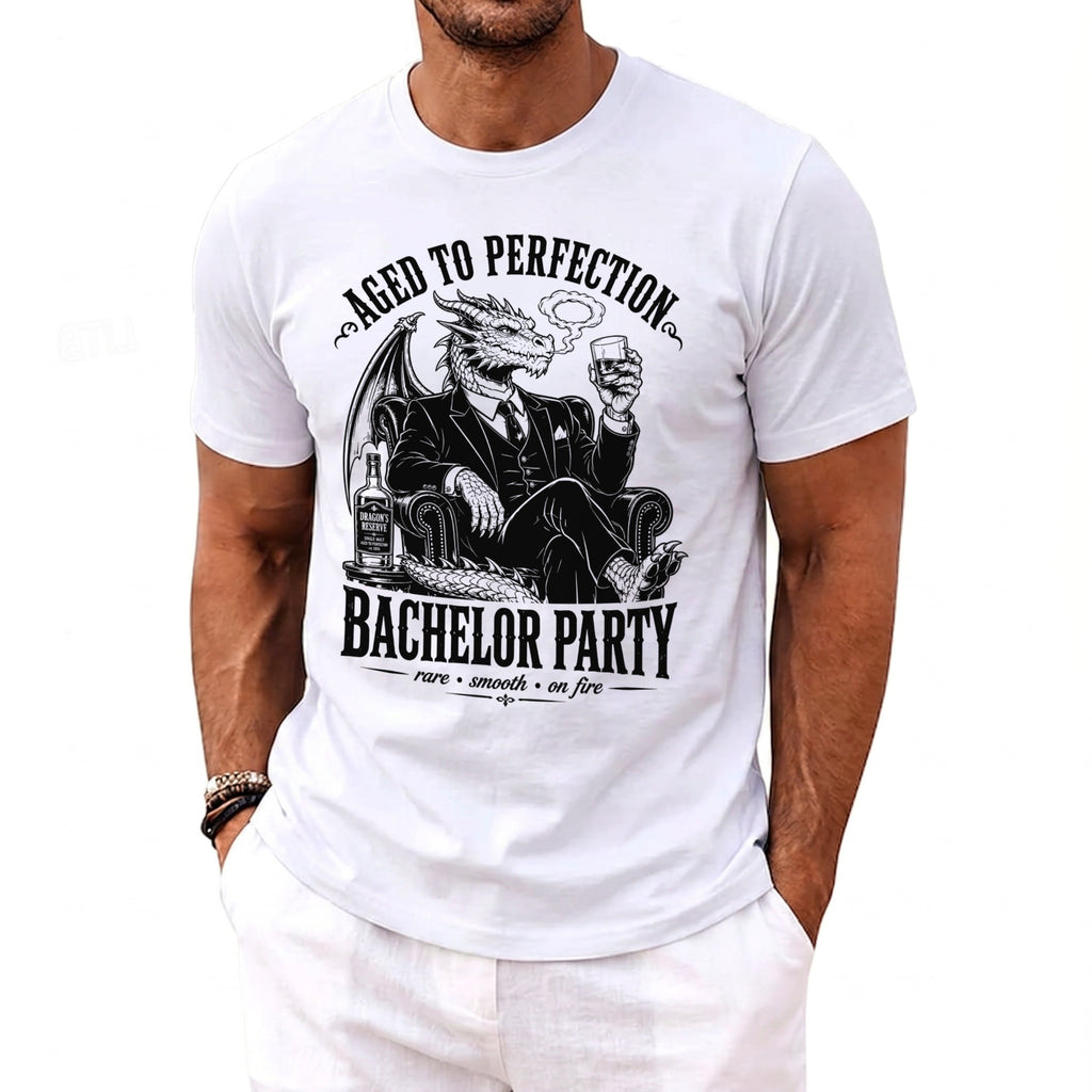 White t-shirt with black graphic of a dragon in a suit, smoking, holding a drink, and "Bachelor Party" text.