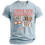 Light blue t-shirt with "Under New Management, Mike's Bach, Est. Summer 2026, LA, CA" graphics.