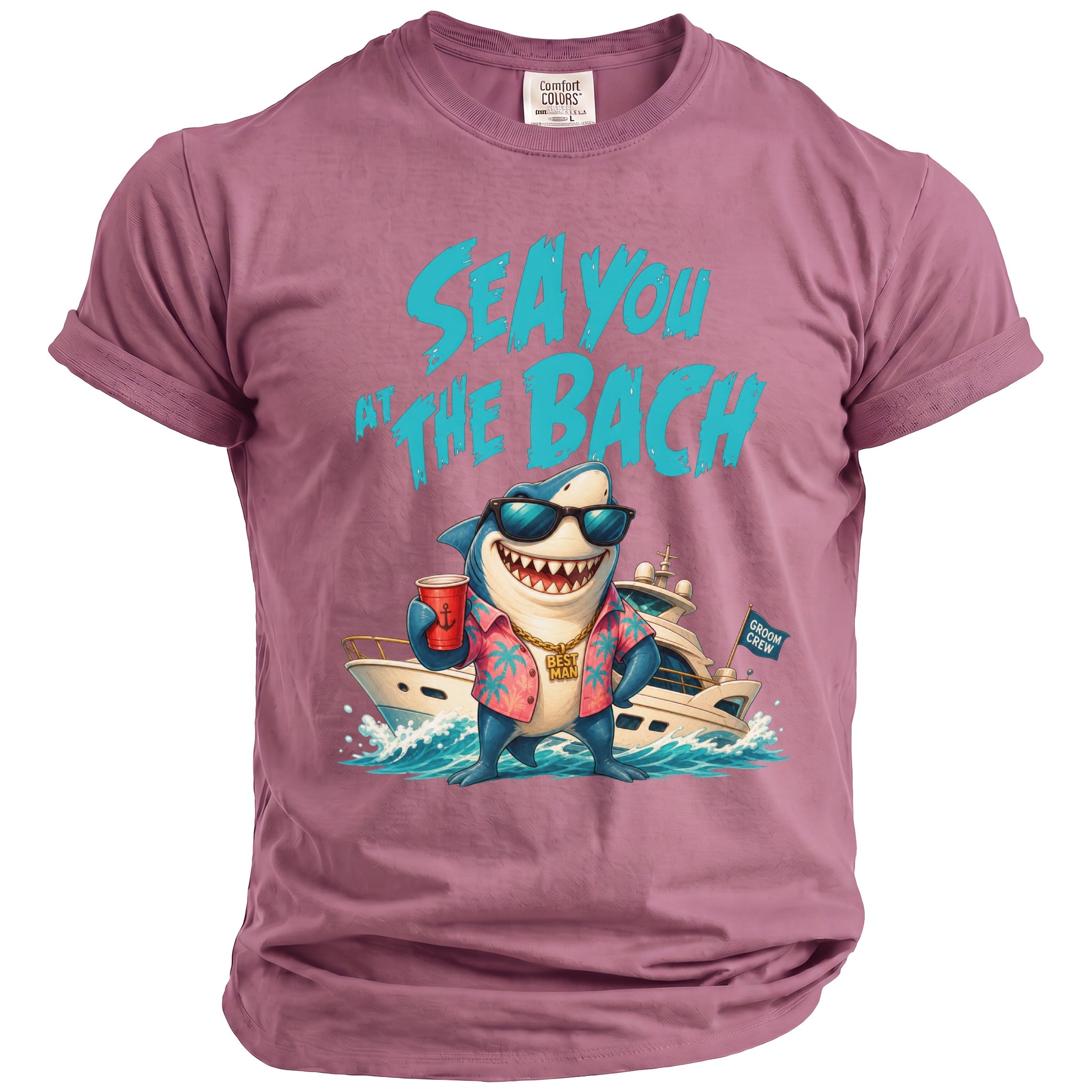 A dusty rose t-shirt features a graphic of a smiling shark wearing sunglasses and a tropical shirt in front of a yacht.