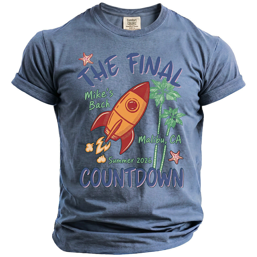 Blue t-shirt with "The Final Countdown" graphic, a rocket, palm trees, and beach elements.