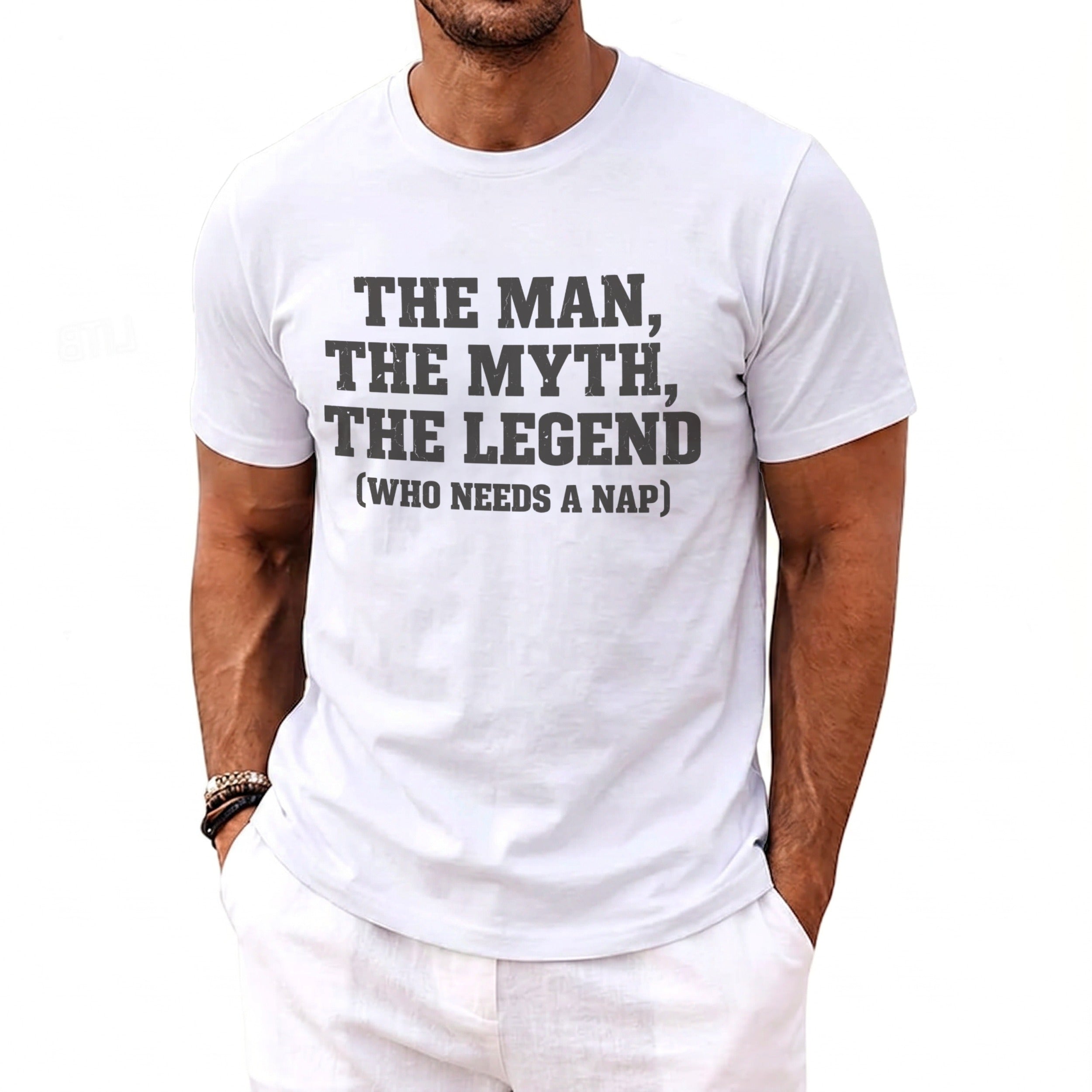White t-shirt with dark gray text reading "THE MAN, THE MYTH, THE LEGEND (WHO NEEDS A NAP)".