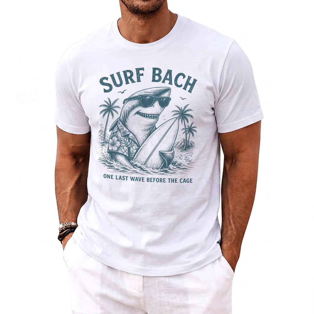 White t-shirt with "Surf Bach" graphic of a shark in sunglasses holding a surfboard.