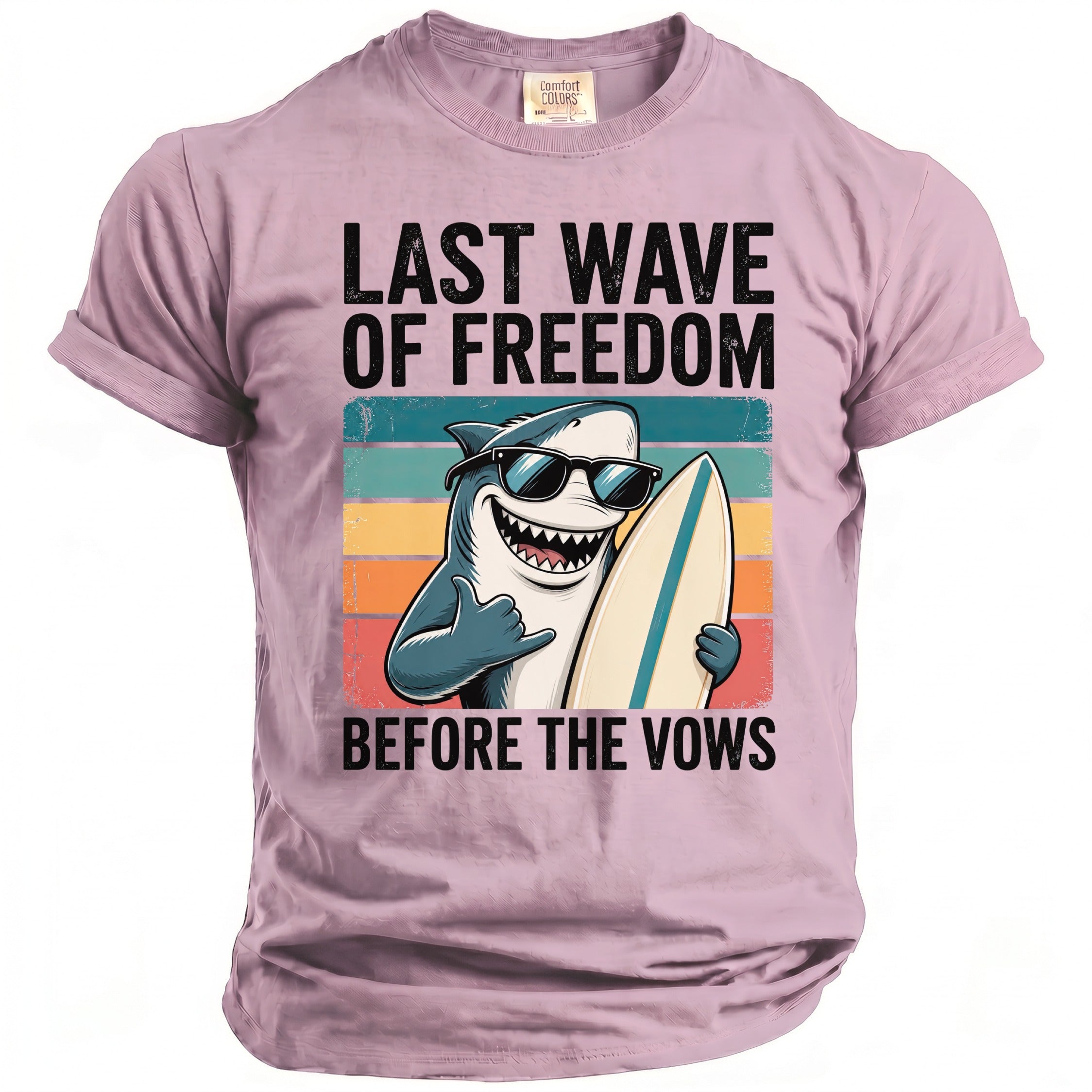 Pink t-shirt with graphic of a shark holding a surfboard and text "LAST WAVE OF FREEDOM BEFORE THE VOWS".