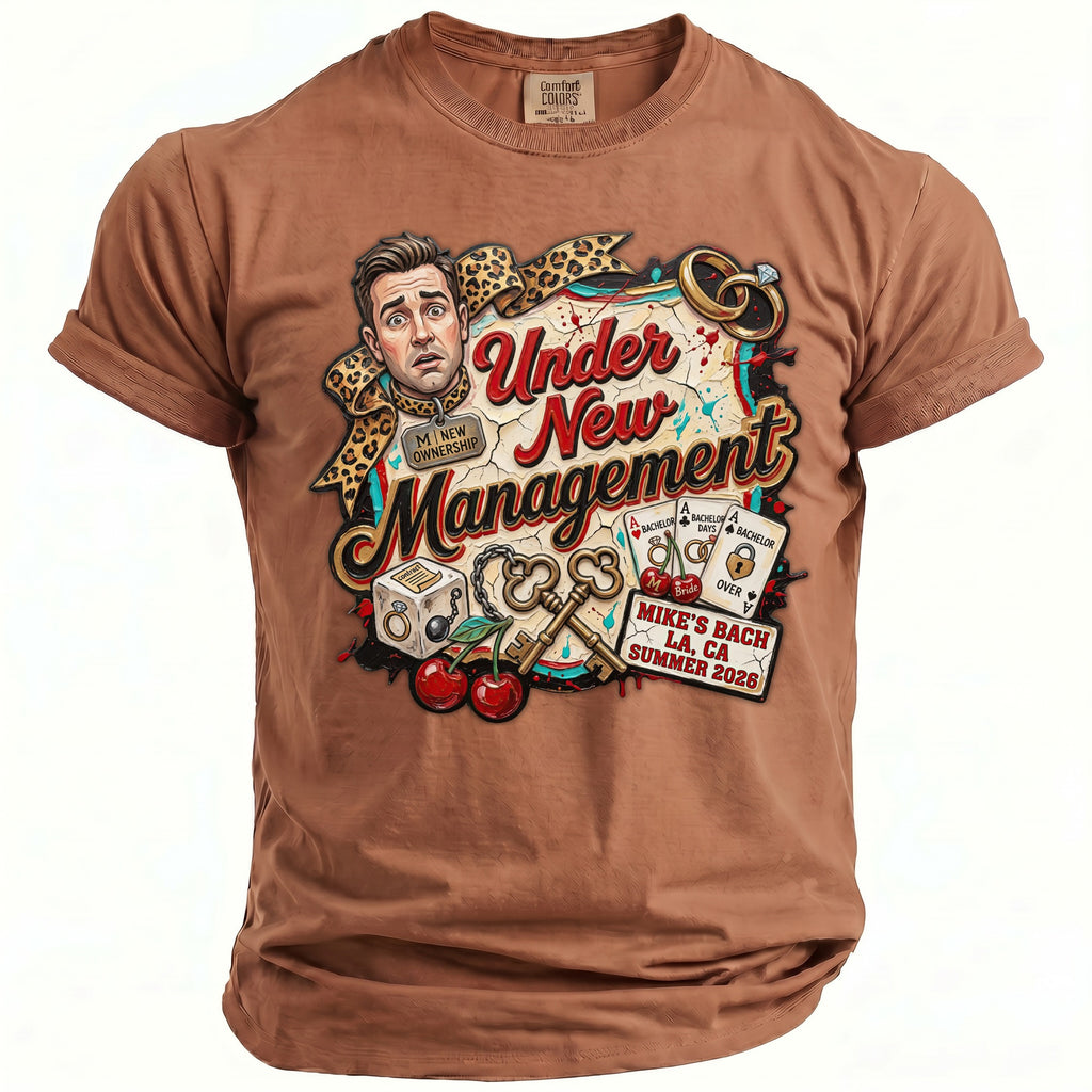 Brown t-shirt with "Under New Management" design featuring a man, keys, rings, and cherries.