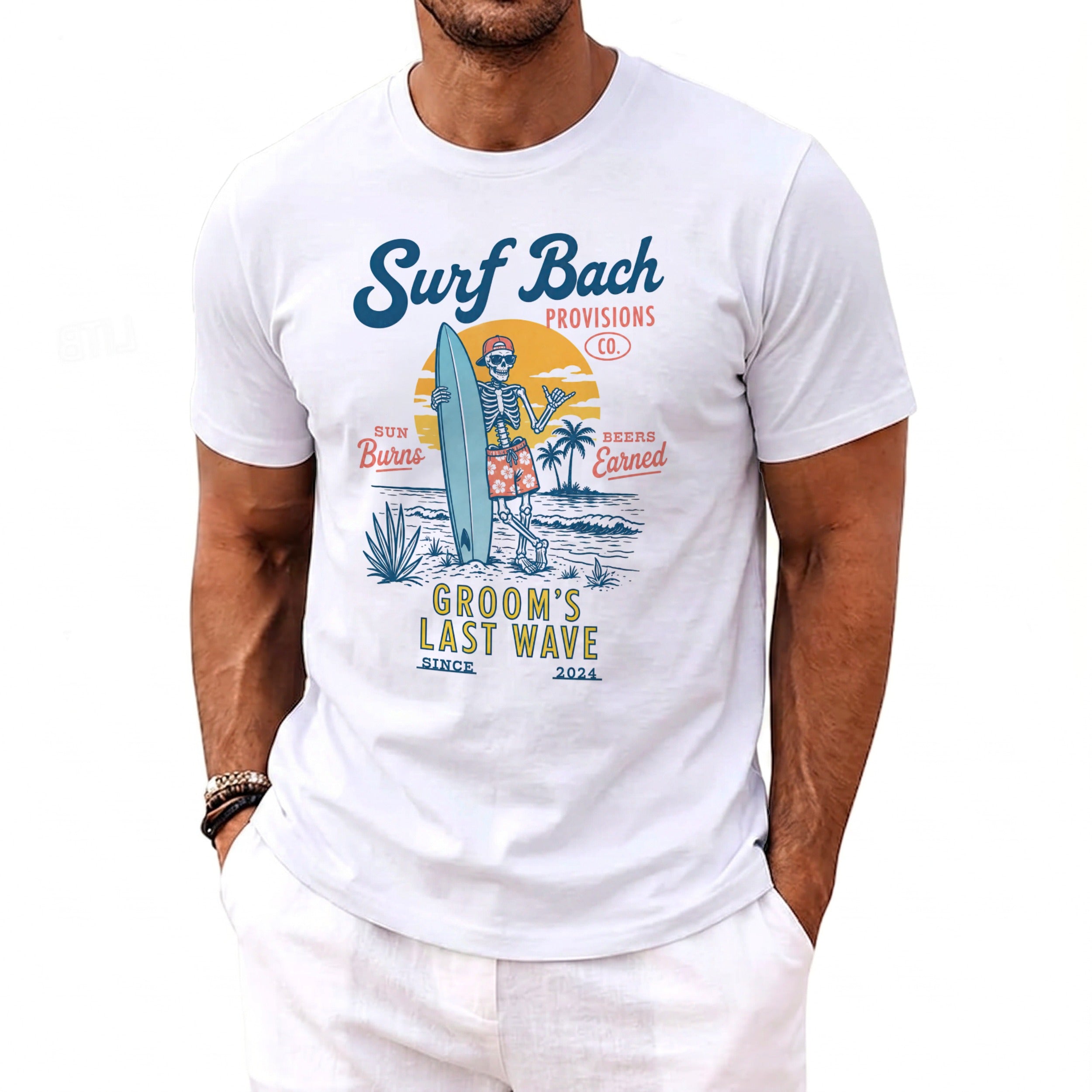 White t-shirt with a skeleton surfer graphic that reads "Surf Bach Provisions Co." and "Groom's Last Wave".