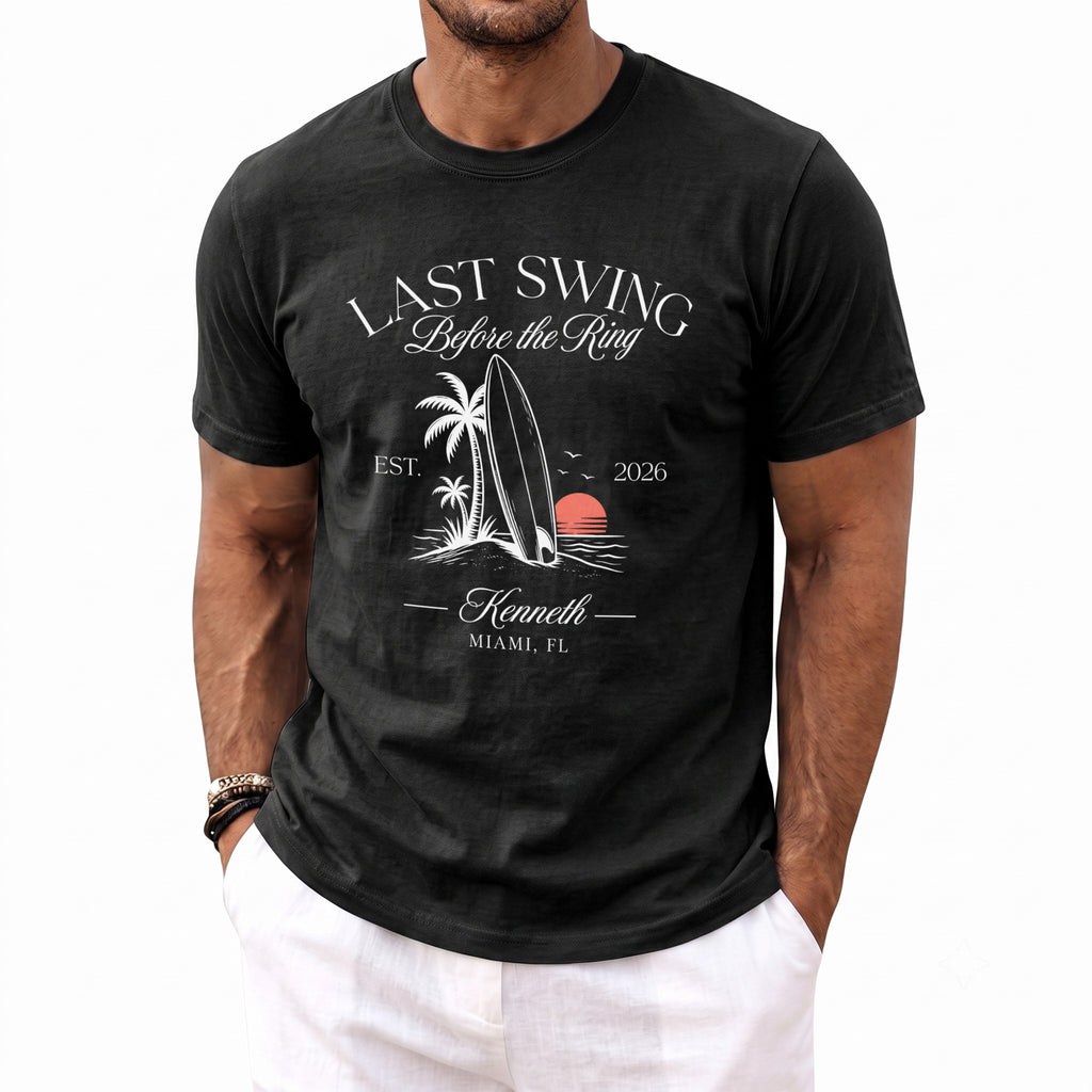 Black t-shirt with "Last Swing Before the Ring" design featuring a surfboard, palm trees, and sunset.