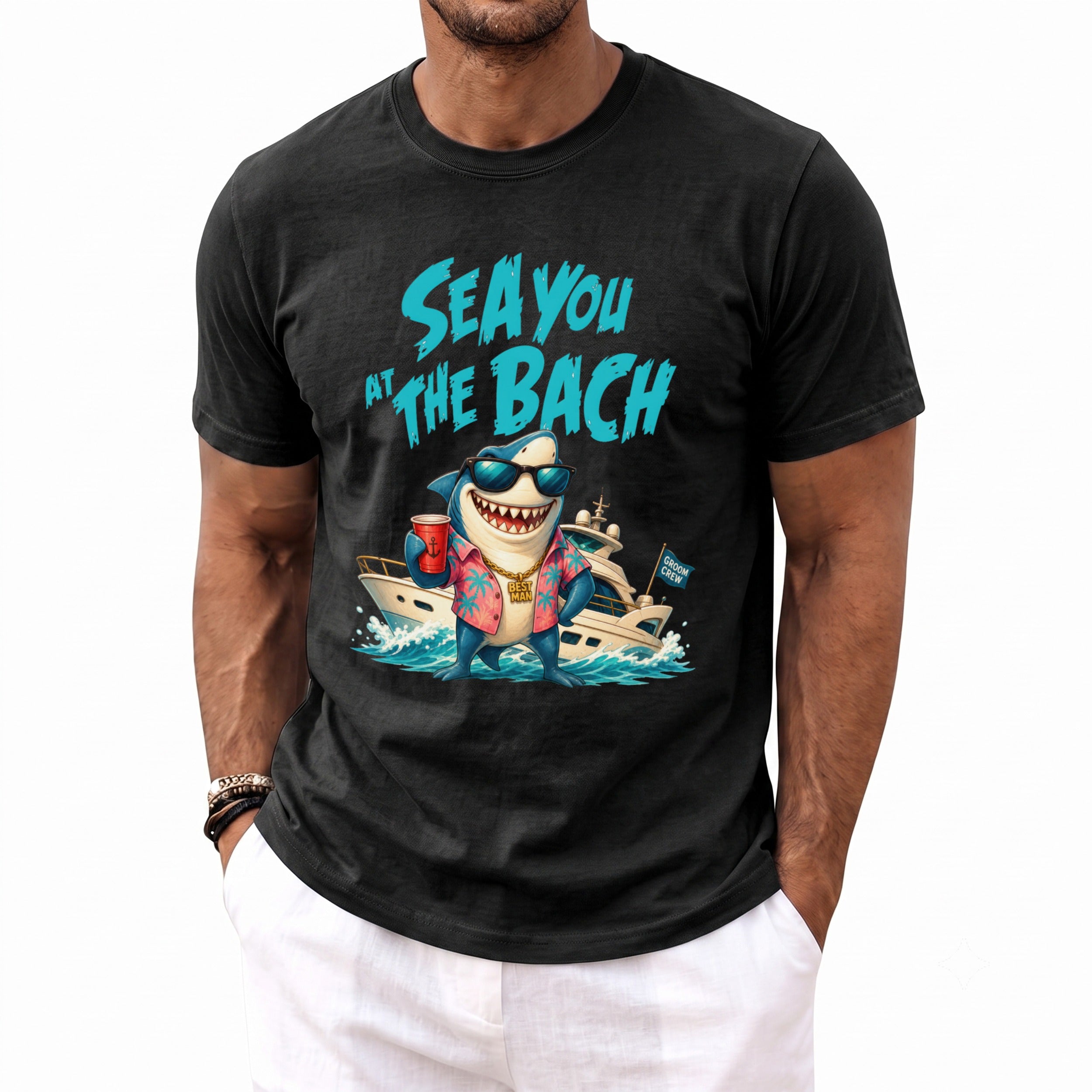 A man wearing a black t-shirt printed with a shark wearing sunglasses and a yacht graphic.