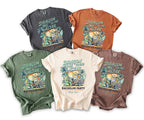 Five t-shirts in different colors featuring a dragon pulling a cart with men and groom.